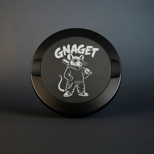 Mattsvart snusdosa i metall med en detaljerad lasergravyr av en kaxig råtta med basebollträ och texten Gnaget, placerad på en neutral mörk bakgrund.