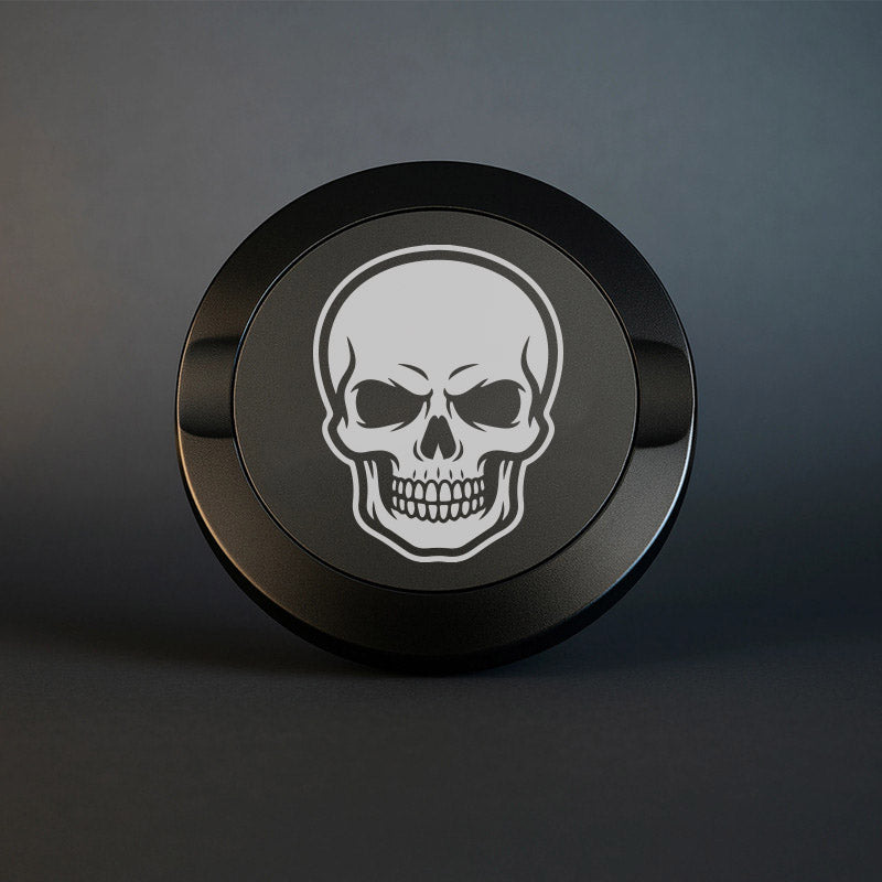 Mattsvart metall snusdosa med detaljerad lasergravyr av en klassisk dödskalle. Tuff premium snusdosa med skull-motiv på mörk bakgrund.