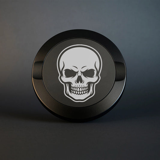 Mattsvart metall snusdosa med detaljerad lasergravyr av en klassisk dödskalle. Tuff premium snusdosa med skull-motiv på mörk bakgrund.