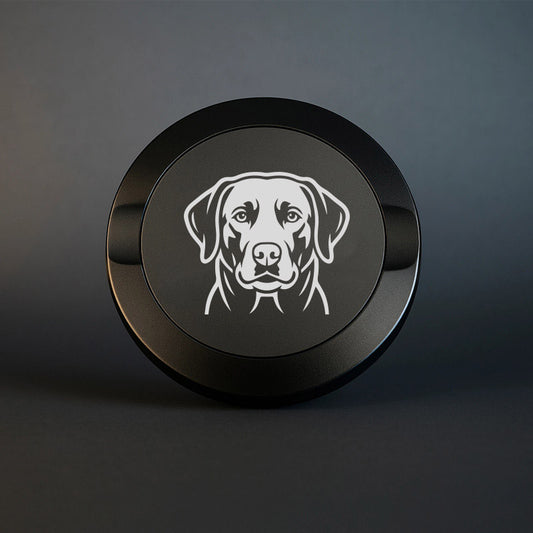 Mattsvart snusdosa i metall med detaljrik lasergraverad labrador på locket, fotograferad mot en mörk stilren bakgrund som framhäver gravyrens skarpa detaljer.