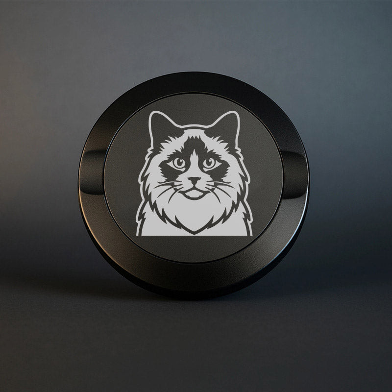Mattsvart metall snusdosa med detaljerad lasergravyr av en fluffig Ragdoll-katt med mörk mask runt ögonen. Premium snusdosa med kattmotiv på mörk bakgrund.