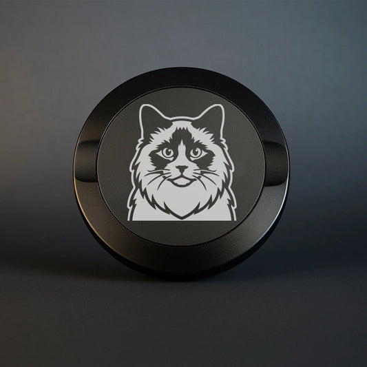 Mattsvart metall snusdosa med detaljerad lasergravyr av en fluffig Ragdoll-katt med mörk mask runt ögonen. Premium snusdosa med kattmotiv på mörk bakgrund.