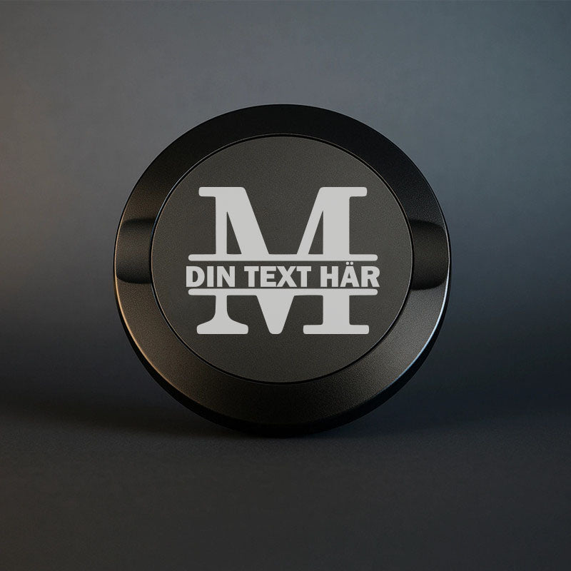 Mattsvart snusdosa i metall med en vacker, stor graverad bokstav M som personligt monogram