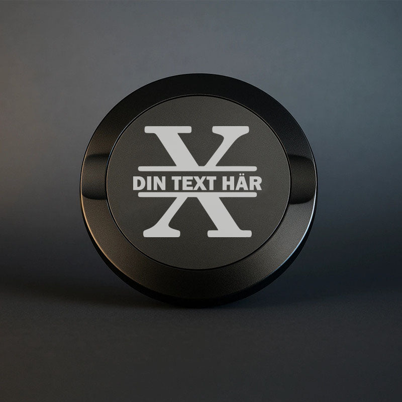 Mattsvart snusdosa i metall med en vacker, stor graverad bokstav X som personligt monogram