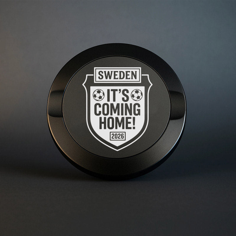 Svart exklusiv snusdosa i metall med ett graverat fotbollsemblem och texten Sweden It's Coming Home 2026.